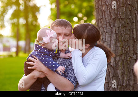 Maman papa et petite fille marche dans le parc Banque D'Images