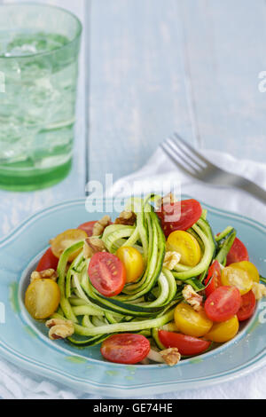 Nouilles aux courgettes aux tomates et noix sautées dans l'huile d'olive Banque D'Images