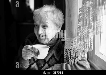 Femme âgée de boire du thé. Photo en noir et blanc. Banque D'Images