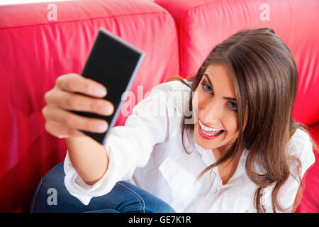 Portrait of happy young woman taking. selfies Belle femme fait face tout en maintenant le téléphone mobile. Elle est assise o Banque D'Images