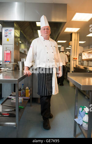 Chef de cuisine à Brighton Race Course se tient dans sa cuisine typique, pose en chef Banque D'Images