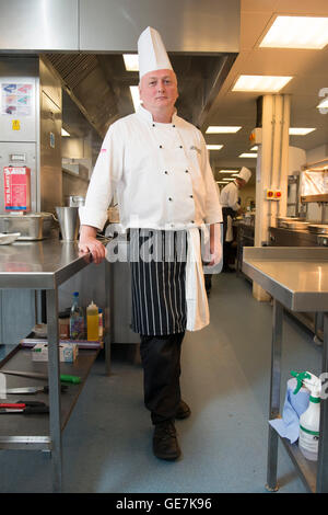 Chef de cuisine à Brighton Race Course se tient dans sa cuisine typique, pose en chef Banque D'Images