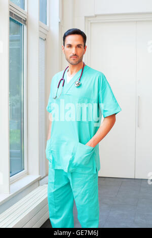 Portrait of male surgeon standing avec la main dans la poche. Certains professionnels médicaux porte des gommages corporels. Il est debout à l'hôpital Banque D'Images