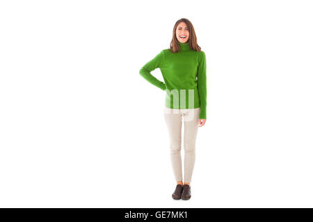 Toute la longueur de jeune femme souriante. Belle femme porte un pull à col roulé vert. Elle se tient isolé sur blanc retour Banque D'Images