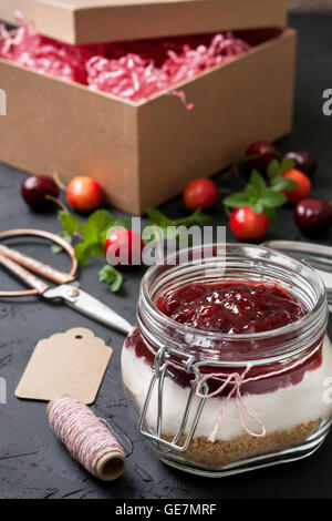 Cadeau fait main n'est pas la cuisson du gâteau au fromage aux cerises dans un bocal en verre Banque D'Images