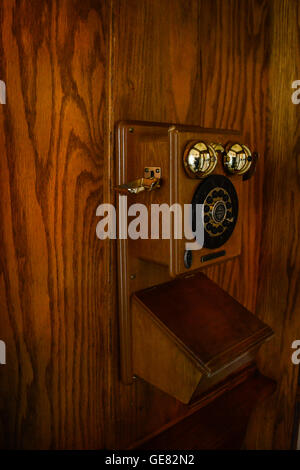 Un moody et nostalgique vue à l'intérieur d'une cabine téléphonique à payer en bois vintage Banque D'Images