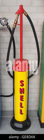 Cette image historique montre une pompe à essence Shell ancienne, mettant en évidence l'évolution de la technologie de distribution de carburant. Ces pompes ont été un élément clé de l'histoire automobile, marquant le développement de systèmes de ravitaillement modernes. Banque D'Images
