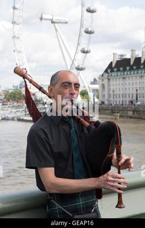 Londres, Royaume-Uni. Le 25 juillet, 2016. Un homme joue de la cornemuse sur le pont de Westminster à Londres Crédit : Keith Larby/Alamy Live News Banque D'Images