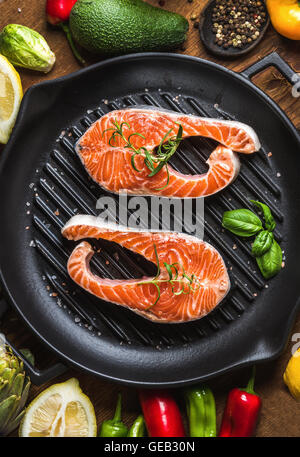 Cuisine dîner ingredints. Matières saumon cru poisson avec légumes, herbes et épices en fer pan cuisson Banque D'Images