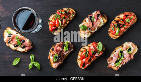 Brushetta des collations pour le vin. Variété de petits sandwiches sur toile rustique en bois foncé Banque D'Images