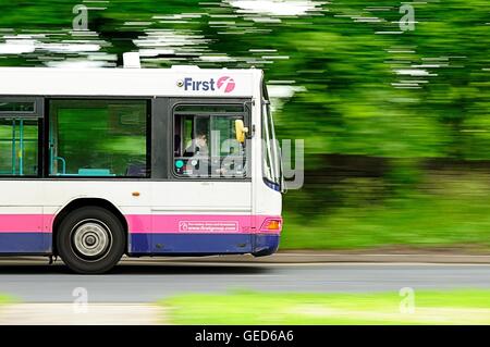 Panoramique d'un premier single decker conduite d'autobus le long d'une route bordée d'un Banque D'Images