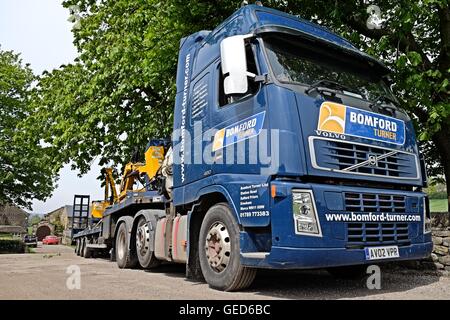 Tracteur Volvo FH et faible loader remorque transportant des équipements de découpe de couverture d'une ferme dans le Yorkshire du Sud Banque D'Images