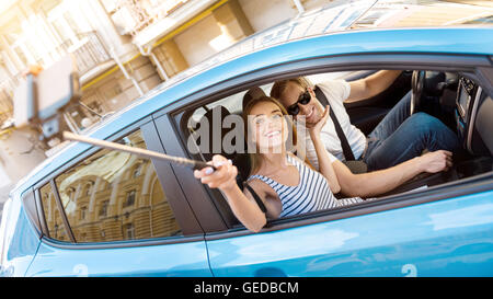 L'homme et de la femme de prendre la voiture en selfies Banque D'Images