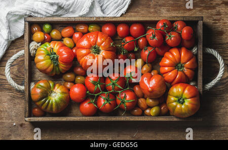 Assortiment coloré de heirloom, bunch et tomates cerises en bac sur fond de bois rustique Banque D'Images