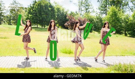 Quatre jeunes filles pretty smiling holding lettres avec le mot amour outdoor le jour d'été ensoleillé Banque D'Images