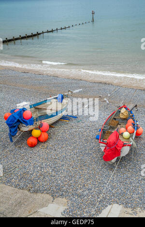 Petits bateaux de pêche échoué sur la plage de galets à Sheringham, Norfolk, Angleterre, Royaume-Uni Banque D'Images