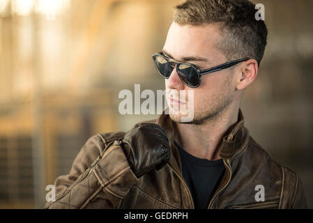 Portrait de jeune homme adultes portant des lunettes de soleil et veste en cuir Banque D'Images