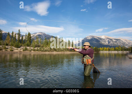 Pêcheur à la mouche dans une rivière de montagne. Banque D'Images
