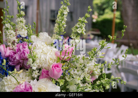 Arrangement de fleurs avec des pivoines et roses en face de grange. Banque D'Images