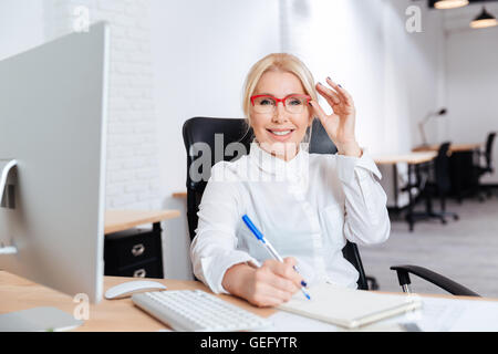 Portrait of a smiling attractive young businesswoman using laptop in office Banque D'Images