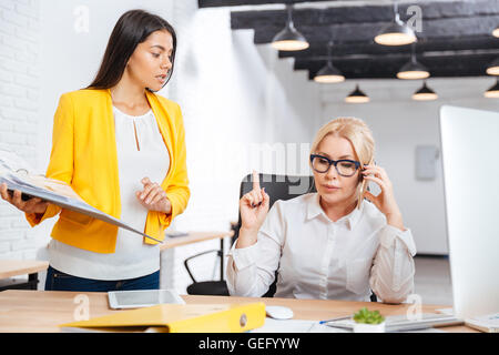 Deux femmes d'intelligente discuter des idées, sur le bureau de l'office Banque D'Images