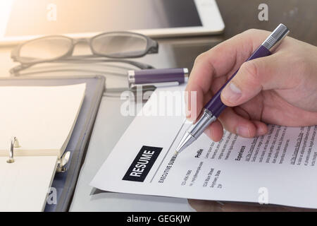 L'homme d'affaires examiner son cv sur son bureau ou l'examen d'emploi son cv avant de l'envoyer à trouver un nouvel emploi. Reprendre l'info Banque D'Images