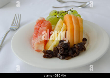 Une assiette de fruits sur la fourchette avec nappe blanche Banque D'Images