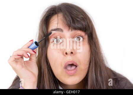 Woman putting on make-up isolé sur fond blanc Banque D'Images