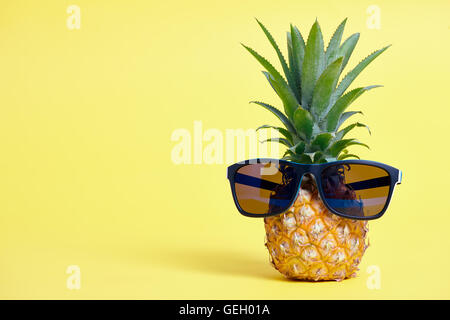 L'ananas avec des lunettes de soleil sur fond jaune Banque D'Images