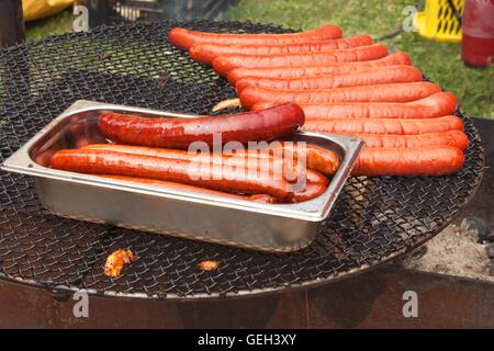 Griller les saucisses sur la grille du barbecue. Banque D'Images
