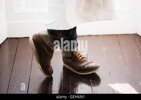 Close up of a man's pieds, portant des chaussures marron avec des lacets orange. Banque D'Images