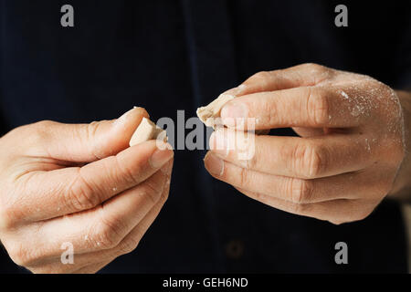 Close up of a baker holding morceaux de levure fraîche dans ses mains. Banque D'Images