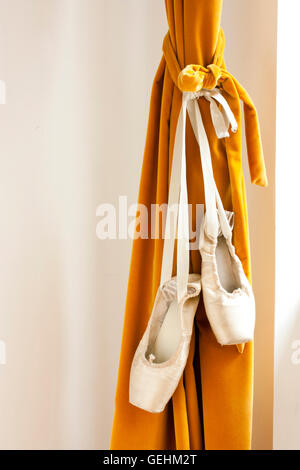 Pointe chaussures de ballet accroché à un rideau de théâtre Banque D'Images