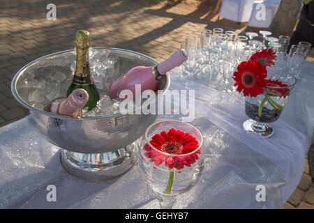Décor de table avec des verres et du Champagne sur la glace dans un bol en argent Banque D'Images