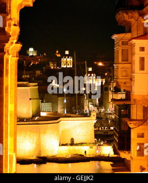 Vue de nuit de Fort St Michael à Sliema de St John's street, à La Valette, Malte montrant un balcon typiquement maltais. Banque D'Images