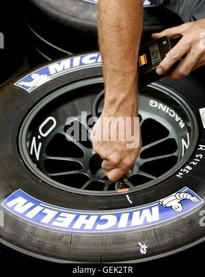 Fichier - Un fichier photo datée du 30 juin 2005 montre un mécanicien de l'équipe de course de Formule 1 Honda BAR contrôle de la pression dans un pneu Michelin au cours de la formation à venir d'un Grand Prix racein Magny-Cours, France. Photo : Kerim Otken Banque D'Images
