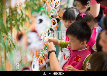 Macao, Chine. 26 juillet, 2016. Les enfants écrivent leurs bénédictions pour grand panda oursons et Dabao Xiaobao dans la Région administrative spéciale de Macao, Chine du sud, le 26 juillet 2016. La femelle panda Xinxin ici a donné naissance aux deux oursons le 26 juin. Une fête pour les deux oursons' fin de leur premier mois de vie est tenue ici mardi. Credit : Cheong Kam Ka/Xinhua/Alamy Live News Banque D'Images