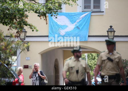 Ansbach, Allemagne. 26 juillet, 2016. Les agents de police passent devant un mur sur lequel une bannière avec une colombe de la paix est bloqué sur le site de l'attaque passé à Ansbach, Allemagne, 26 juillet 2016. 15 personnes ont été blessées dans une attaque motivée-islamistes présumés le 24 juillet 2016. L'auteur présumé, un homme de 27 ans pour les réfugiés en provenance de Syrie, a été tué dans l'explosion. Photo : DANIEL KARMANN/dpa/Alamy Live News Banque D'Images