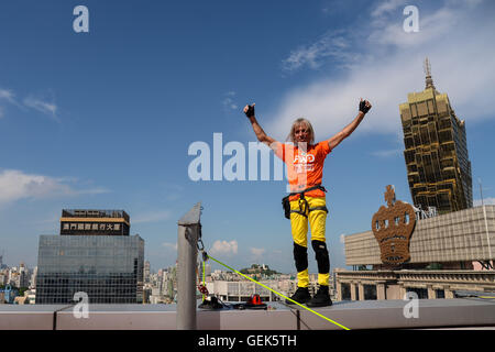 Macao, Chine. 26 juillet, 2016. Grimpeur urbain français Alain Robert surnommé Spiderman, vagues après ce qu'il atteint le sommet de la Fortuna Centre d'affaires à Macao, Chine du sud, le 26 juillet 2016. Credit : Cheong Kam Ka/Xinhua/Alamy Live News Banque D'Images