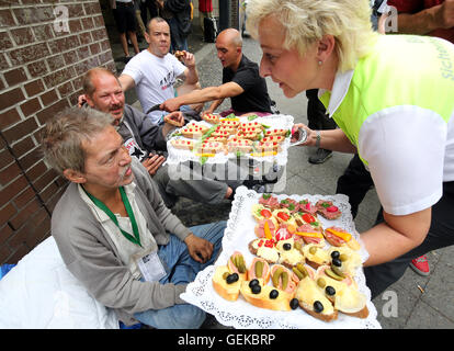 Berlin, Allemagne. 27 juillet, 2016. Avec un employé du service de sécurité de la BVG les mains hors des sandwichs à gauche plus de la visite du ministre des Affaires étrangères pour les sans-abri à l'extérieur de la Mission évangélique de la gare Zoologischer Garten de Berlin, Allemagne, 27 juillet 2016. Photo : WOLFGANG KUMM/dpa/Alamy Live News Banque D'Images