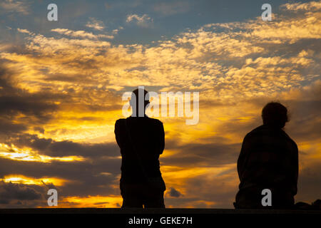 Southport, Merseyside, Royaume-Uni. 27 juillet, 2016. Ciel toujours colorés sur la mer d'Irlande en tant que photographe et sa femme attendre les maquereaux ciel pour être éclairé avec l'orange brille du soleil couchant. Et toujours très stable avec une variété de nuages signalant l'apparition de mauvais temps pluvieux et humide pour les prochaines 24 heures. Credit : MediaWorldImages/Alamy Live News Banque D'Images