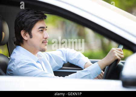 Young Chinese man driving car Banque D'Images