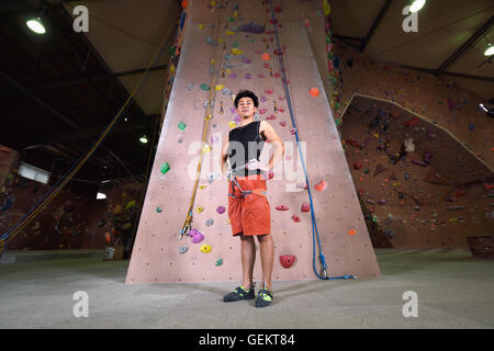 Athlète escalade japonais s'apprête à escalader le mur de sport Banque D'Images