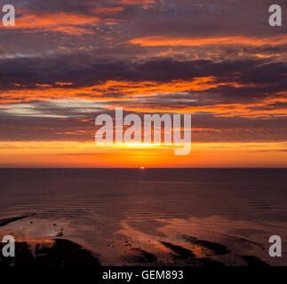 Lever du soleil sur la mer du Nord à partir de Robin Hoods Bay sur la côte du Yorkshire du Nord. L'Angleterre. UK Banque D'Images