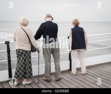 Deux femmes âgées et un homme marche sur la jetée victorienne Saltburn. Marseille par la mer, Yorkshire du Nord. L'Angleterre. UK Banque D'Images