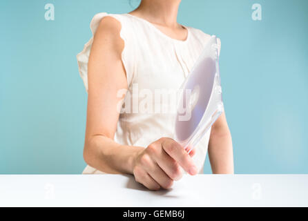 Businesswoman holding DVD-ROM Banque D'Images