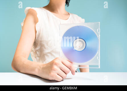 Businesswoman holding DVD-ROM Banque D'Images