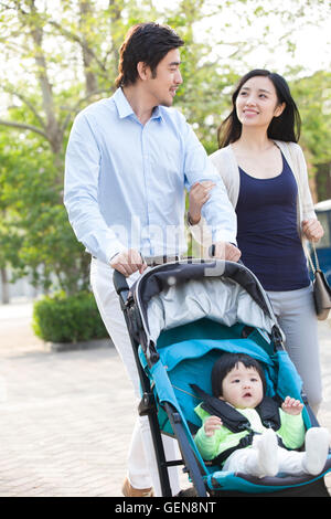 Jeune couple chinois de prendre une marche avec leur bébé dans la pram Banque D'Images