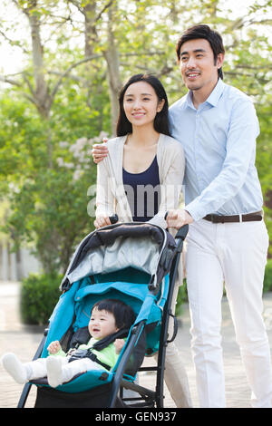 Jeune couple chinois de prendre une marche avec leur bébé dans la pram Banque D'Images