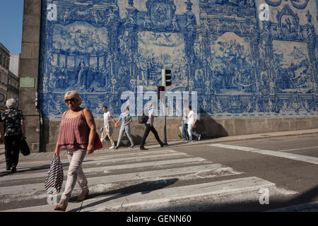 Les piétons passent sous tuiles azulejo traditionnel sur le mur de Capela Das Almas (église), sur la Rua Santa Catarina, Porto Banque D'Images